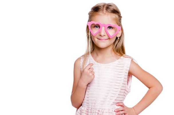 Красива дівчина в рожевій сукні і окулярах з картону у вигляді сердець
 - Фото, зображення