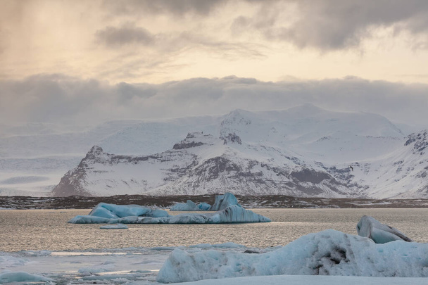 Glacier ice floating on the water with snow at glacier lagoon in the winter time in Iceland. - Φωτογραφία, εικόνα
