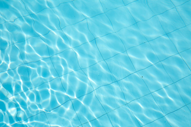 aufgerissenes Wasser im Schwimmbad. Oberfläche des blauen Schwimmbeckens, Hintergrund des Wassers im Schwimmbad. - Foto, Bild