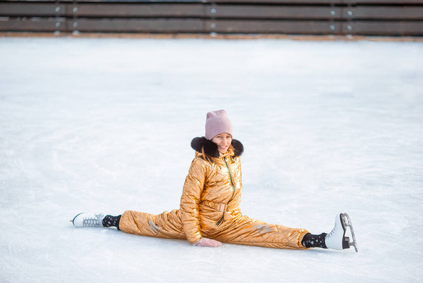 Pequena menina adorável sentado no gelo com patins após o outono
 - Foto, Imagem