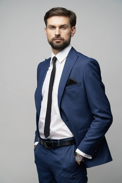 studio photo of young handsome stylish businessman wearing suit - Foto, imagen
