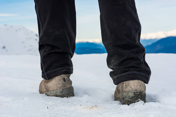 Low angle view of person walking on snow covered mountain ridge. - 写真・画像