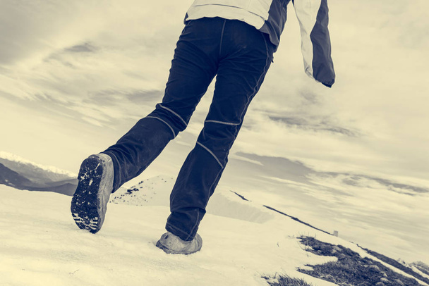 Alacsony szög kilátás személy séta havas hegygerincen. - Fotó, kép