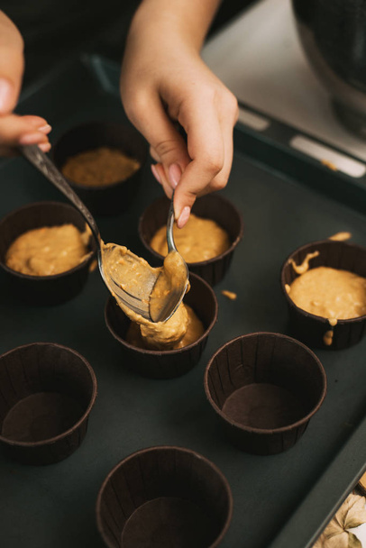 Pekař vyrábí dortíky ve formách. Pekař vytváří mrkvové muffiny - Fotografie, Obrázek