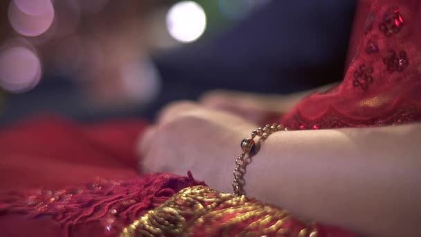 Noiva de vestido de noiva vermelho chorando. A rapariga tem uma pulseira de ouro no braço. Cabeça e rosto da noiva cobertos com véu de tule. Casamento étnico. Noiva emocional chorando com guardanapo nas mãos
. - Filmagem, Vídeo
