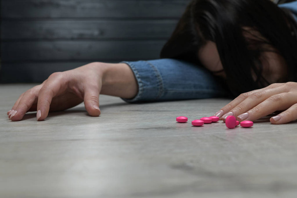 Young woman lie on the floor after overdose the medical pills - Photo, Image