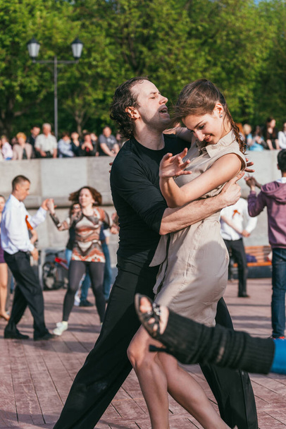 MOSCOW, RUSSIA-MAY 09, 2015: people are dancing outdoors in the Park on Pushkinskaya embankment at sunny day - Foto, Bild