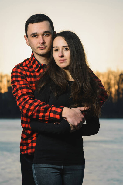 The guy and the girl in the park stand on the ice of the lake on Valentine's day. - Foto, Bild