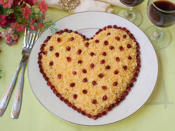 Festsalat in Herzform, dekoriert mit Granatapfelkernen, Dekorationsidee zum Valentinstag, horizontale Ausrichtung, Draufsicht - Foto, Bild