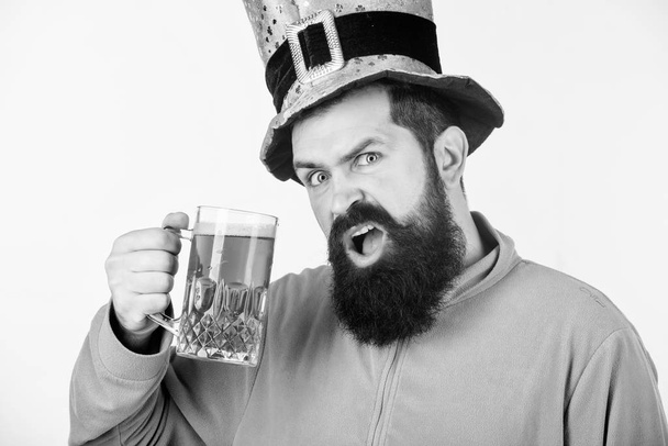 Take it easy this paddys day. Irish man with beard drinking green beer. Celebrating saint patricks day in bar. Hipster in leprechaun hat holding beer mug. Bearded man toasting to saint patricks day - 写真・画像