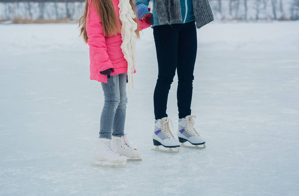 Girl teenager with mother skating in white skates on the ice area - Photo, Image