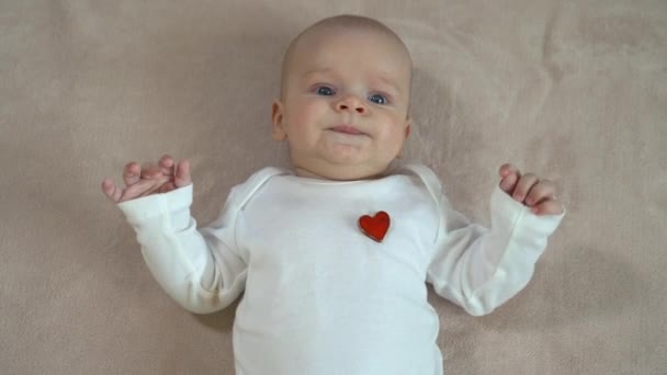 Bebê bonito jaz nas costas e sorrindo
 - Filmagem, Vídeo