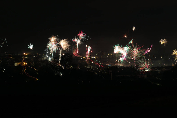 Fuegos artificiales sobre la ciudad por la noche. Fotografía de larga exposición. Concepto de celebración
. - Foto, imagen
