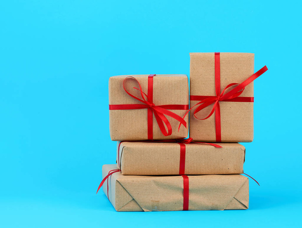 stack of boxes wrapped in brown paper and tied with a red bow, g - Photo, Image