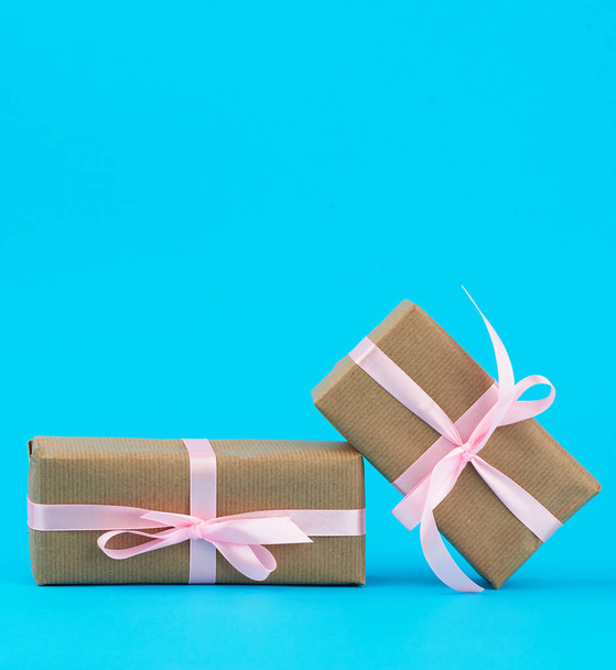  gifts in boxes wrapped in brown kraft paper and tied with pink  - Фото, зображення
