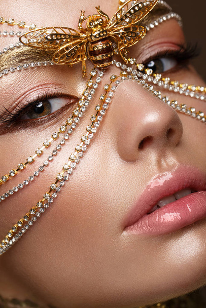 Beautiful girl in golden mask and bright evening make-up. Beauty face. - Фото, зображення