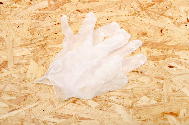 Guantes desechables sobre un fondo de tablero de madera contrachapada OSB
 - Foto, Imagen