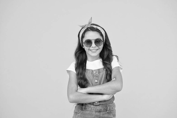 ready for sunny weather. Summer fashion concept. cheerful little girl yellow background. retro kid long hair. small kid vintage sunglasses. Vacation mode on. small fashionista. Kids clothes boutique - 写真・画像