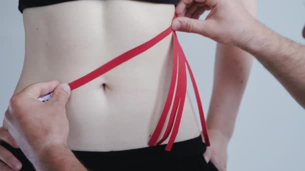 Άτομο με κόκκινη ταινία κινησιολογίας στο στομάχι σε ιδιωτική κλινική - Πλάνα, βίντεο