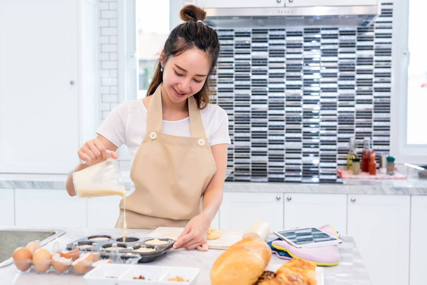 Aasian kauneus nainen ruoanlaitto ja leivonta evästeet keittiössä huoneessa
 - Valokuva, kuva