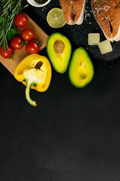 Egészséges, kiegyensúlyozott szuperételek, friss lazac, zöldségek, gabonafélék fekete alapon - Fotó, kép