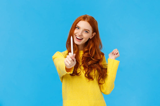 Be author of your own future. Cheerful and creative excited redhead woman giving you pen and smiling, want autograph, want friend draw something, smiling joyfully, standing blue background - Fotó, kép