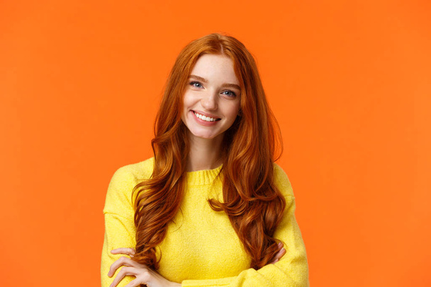 E-commerce, professionalism and employement concept. Cheerful pleasant redhead curly-haired woman in yellow sweater, standing confident with crossed arms and smiling camera - Photo, image
