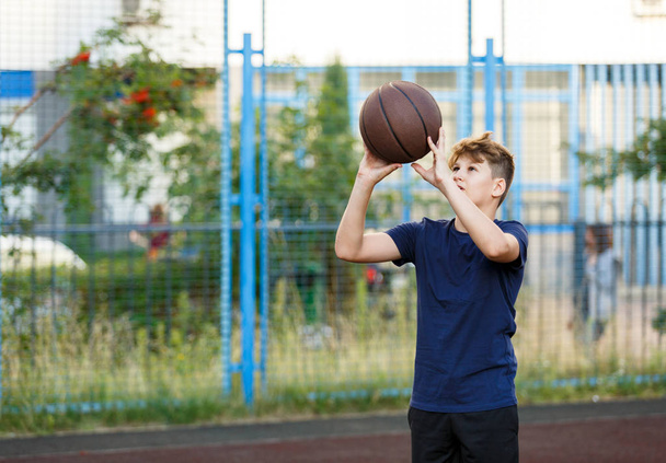 chłopiec gra w koszykówkę na boisku - Zdjęcie, obraz