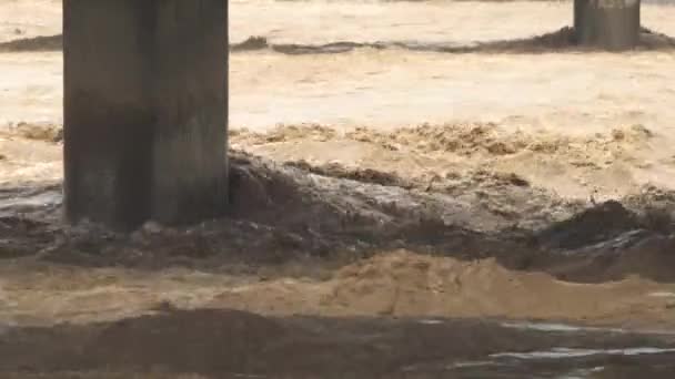Flood waters between bridge columns. Thick large big concrete poles under. Flowing river after strong rain. An incredibly fast flow raging river. Giant roiling water. Foamy stream dangerous wild river - Footage, Video