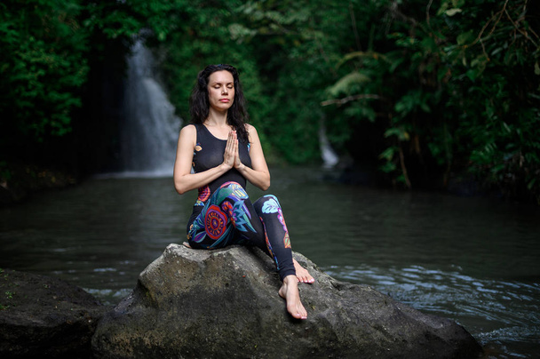 Йога практикує і медитує в природі. Жінка практикувалася біля річки. - Фото, зображення
