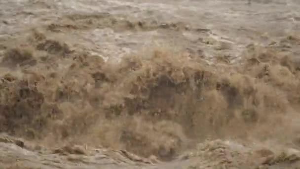 Brown muddy sea waves. Flood waters join reach the sea. Creates strong wave at the mouth of the river. Soil mud is moving towards the sea after rain. An incredibly fast flowing raging river ocean. - Footage, Video