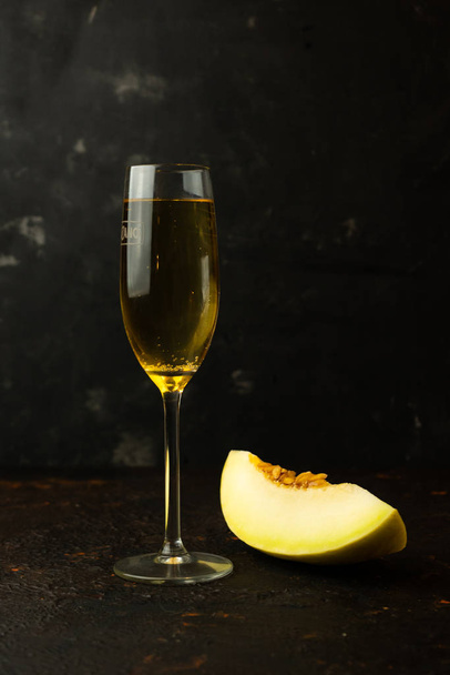 succosa melone giallo con un bicchiere di champagne
 - Foto, immagini