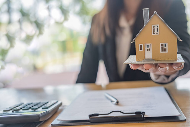 Model domu na agenta, który pokazuje klientom, aby kupić, uzyskać ubezpieczenie, nieruchomości pożyczki lub nieruchomości. - Zdjęcie, obraz