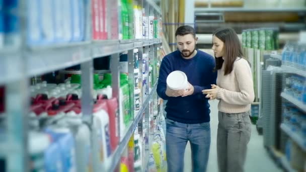 Házaspár egy építőipari szupermarketben válassza a festéket a javításhoz. - Felvétel, videó