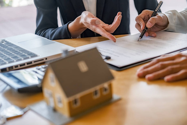 Model domu z agentem i klientem omawiającym umowę kupna, ubezpieczenia lub pożyczki nieruchomości lub nieruchomości. - Zdjęcie, obraz