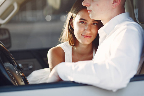 Beautiful couple spend time in a summer city in a car - Photo, image