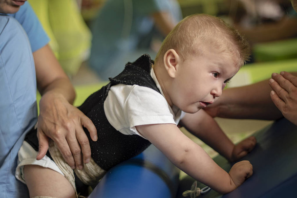 Retrato de un bebé con parálisis cerebral en fisioterapia
  - Foto, Imagen