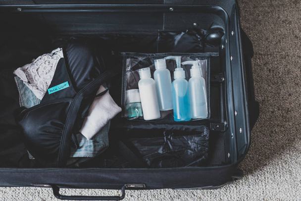 luggage with few items inside and Packing Light label on them - 写真・画像