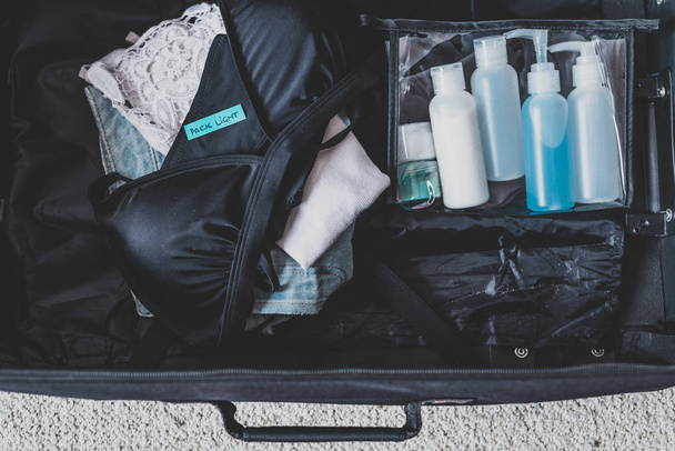 luggage with few items inside and Packing Light label on them - Valokuva, kuva