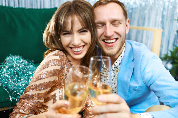 happy romantic couple clinking glasses with sparkling wine, enjoying evenrning party, having date at Valentines Day. - Foto, Bild
