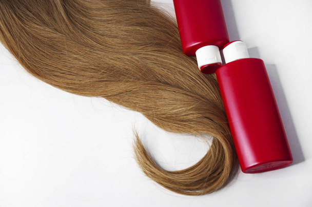 Schöne lange Haare und Shampoo-Flaschen auf weißem Hintergrund - Foto, Bild