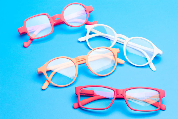 Colored glasses on plain background, modern glasses for fashion. - Photo, Image