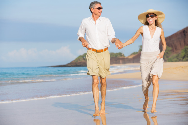 Couple moyen-âge jouissant d'une promenade sur la plage
 - Photo, image