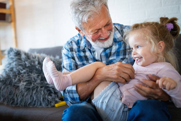 Happy grandparent playing and having fun with their granddaughter - Fotoğraf, Görsel