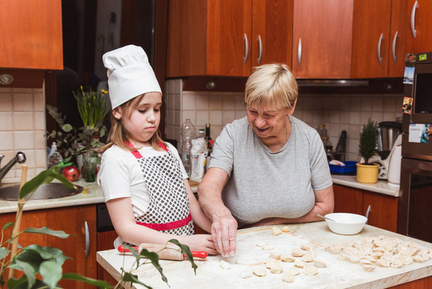 Kislány nagymama a konyhában szobrok gombócok - Fotó, kép