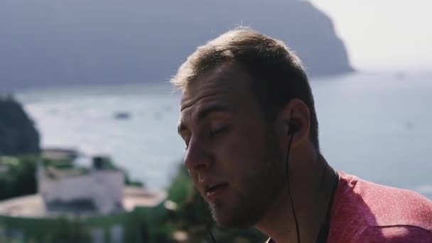 Headphones for listening to music. The guy listens to music through bluetooth headphones. - Imágenes, Vídeo