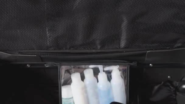 travel essentials for a holiday, luggage with few clothes inside and Packing Light label on them with camera panning vertically - Filmagem, Vídeo