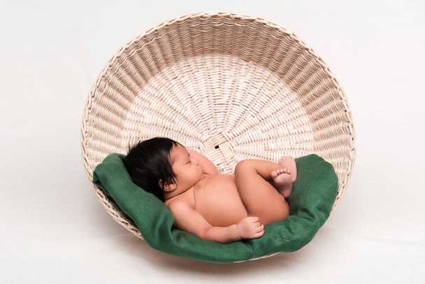 cute newborn mixed race baby sleeping in basket on white - Foto, afbeelding