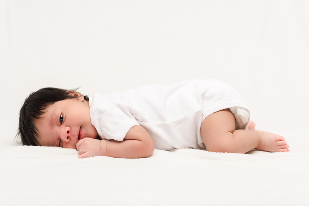 αξιολάτρευτο bi-φυλετικό νεογέννητο στο μωρό romper βρίσκεται απομονωμένο σε λευκό  - Φωτογραφία, εικόνα