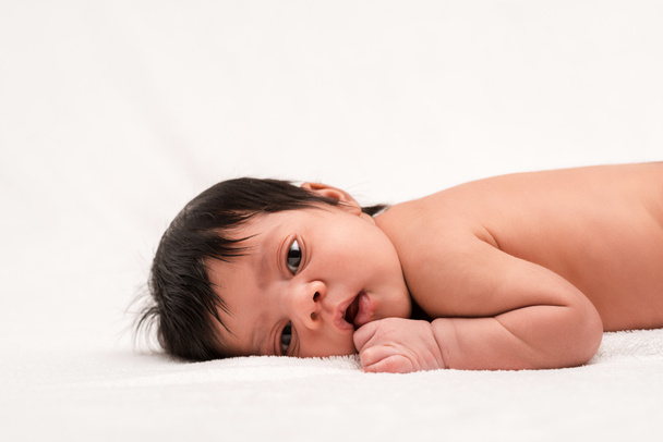 очаровательный двурасовый и голый новорожденный ребенок лежит на белом
  - Фото, изображение